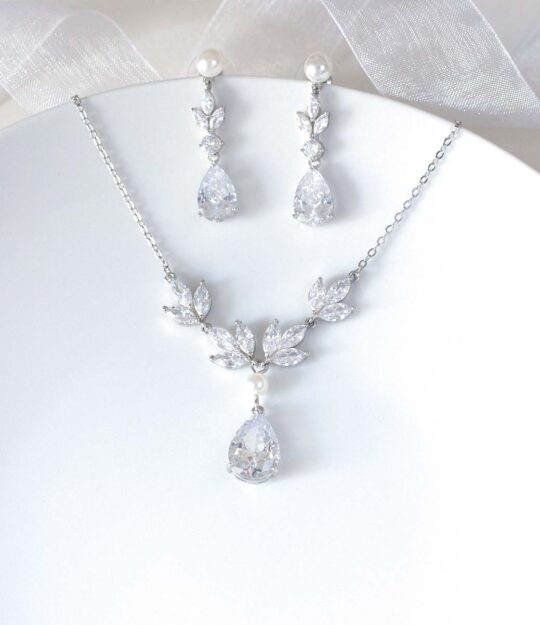 https://www.aurorasecrets.fr/mariage/bijoux-mariage/parure-bijoux-mariage/parure-bijoux-mariage-elegant-collier-boucles-cristal-perles-kely